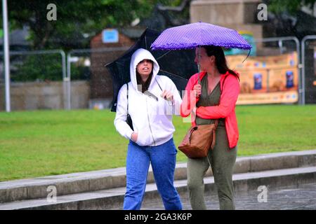 Gewitter und heftiger Regen im Stadtzentrum von Manchester, Großbritannien. Die Menschen versuchen, den Regen im Stadtzentrum am 28. Juli 2021 zu vermeiden. Stockfoto