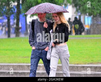 Gewitter und heftiger Regen im Stadtzentrum von Manchester, Großbritannien. Die Menschen versuchen, den Regen im Stadtzentrum am 28. Juli 2021 zu vermeiden. Stockfoto