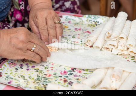 Hausfrau, die Käse in Yufka legt, macht traditionelle türkische sigara Boregi (Zigarette borek). Stockfoto