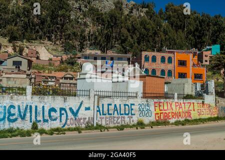 COPABA, BOLIVIEN - 13. MAI 2015: Von einem Wahlkampf bemalte Mauer vor einem Friedhof in Copaba, Bolivien. Stockfoto