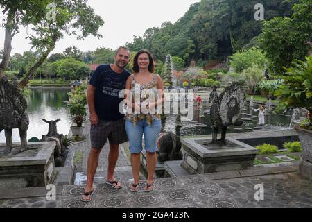 Bali, 23. März 2020 Touristisches Paar im Königengarten Tirta Gannga. Glückliches, liebevolles Paar in Taman Tirtagangga, Wasserpalast, Wasserpark, Bali Stockfoto