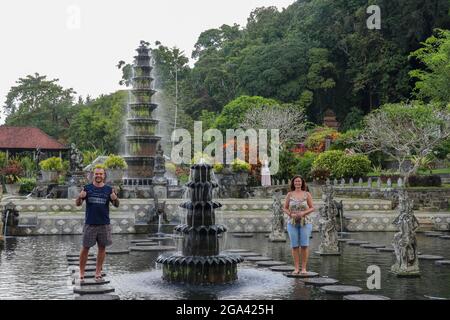 Bali, 23. März 2020 Touristisches Paar im Königengarten Tirta Gannga. Glückliches, liebevolles Paar in Taman Tirtagangga, Wasserpalast, Wasserpark, Bali Stockfoto