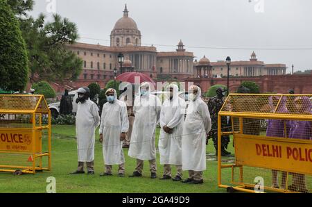 Neu-Delhi, Indien. Juli 2021. Die Polizei von Delhi trägt Gesichtsmasken und Regenmäntel, während sie während des Monsunregens in Vijay Chowk im Dienst ist. Starke Regenfälle haben zur Wasserabholzungen auf der Straße in der Landeshauptstadt geführt. (Foto von Naveen Sharma/SOPA Images/Sipa USA) Quelle: SIPA USA/Alamy Live News Stockfoto