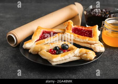 Teller mit dänischem Gebäck auf dunklem Hintergrund Stockfoto