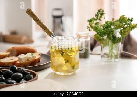 Glas mit leckeren Feta-Käse mit Olivenöl auf dem Tisch in der Küche Stockfoto