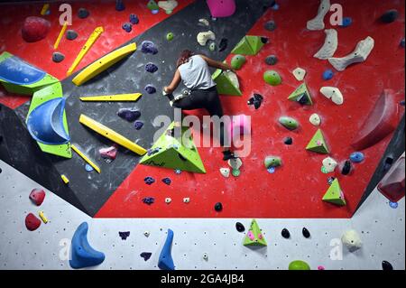 New York City, USA. Juli 2021. Eine junge Frau erkundet eine Boulderroute auf dem Mezzanine des Cliffs LIC Climbing and Fitness Center im Stadtteil Queens von New York City, NY, 28. Juli 2021. Die 20,000 Quadratfuß Space ist ein Fitnesscenter, das dem Klettern gewidmet ist und Bouldern (kein Seil oder Partner erforderlich), Toprope Klettern bietet, wo Seil und Partner helfen, und Lead Climbing, wo ein Partner Sie feststellt, während Sie die Wand hochbewegen und das Seil auf dem Weg verankern. (Anthony Behar/Sipa USA) Quelle: SIPA USA/Alamy Live News Stockfoto