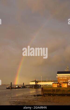 Gravesend UK EIN Regenbogen über der Themse in der Nähe von Gravesend heute Abend. Das Bild zeigt den Royal Terrace Pier der Port of London Authority. Stockfoto