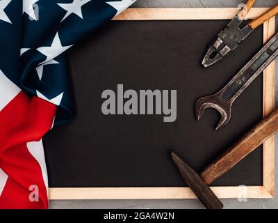 ARBEITSTAG. Handwerkzeuge und die Flagge der Vereinigten Staaten von Amerika liegen auf dem Tisch. Blick von oben, Nahaufnahme. Herzlichen Glückwunsch an die Familie, die Verwandten Stockfoto