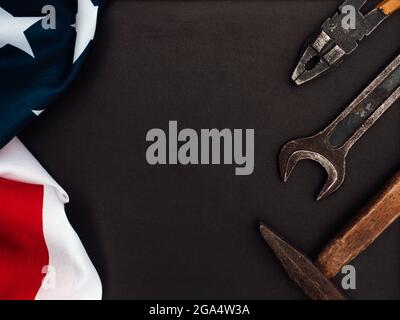 ARBEITSTAG. Handwerkzeuge und die Flagge der Vereinigten Staaten von Amerika liegen auf dem Tisch. Blick von oben, Nahaufnahme. Herzlichen Glückwunsch an die Familie, die Verwandten Stockfoto