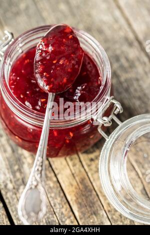 Rote Himbeeren Marmelade im Glas auf Holztisch. Stockfoto