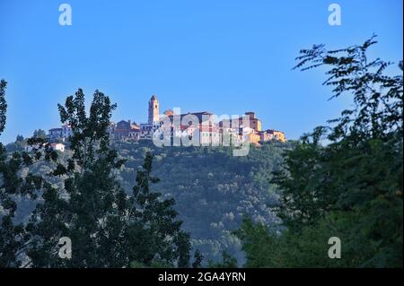 Mediterrane Stadt auf dem Hügel durch die Zweige Stockfoto