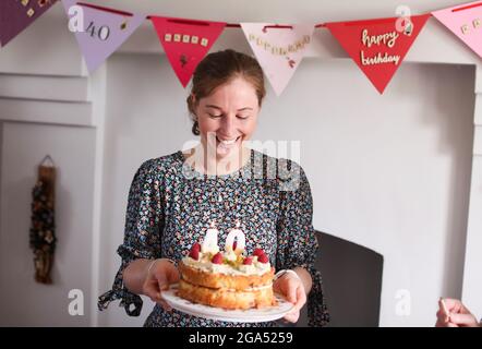 Eine Frau feiert ihren 40. Geburtstag, indem sie die Kerzen auf ihrem Geburtstagskuchen in Armoy, County Antrim, Nordirland, ausbläst. Stockfoto