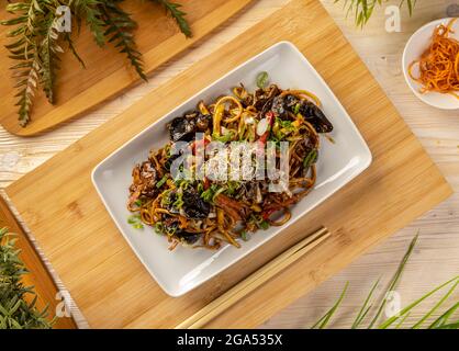 Flache Laie von leckeren asiatischen Nudeln mit Gemüse. Vegetarisches Gericht im asiatischen Stil Stockfoto