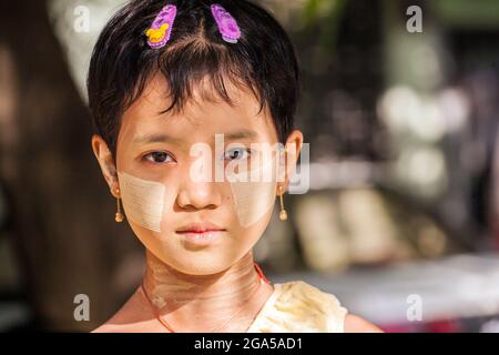 Schöne junge burmesische Mädchen mit Thanaka auf Gesicht Posen für Foto, Mandalay, Myanmar Stockfoto