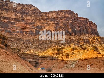 Abgeschiedener Campingplatz unter Klippen in der Nähe der Mexican Mountain Road und des San Rafael River bei Sonnenuntergang, in der Nähe von Buckhorn Wash, San Rafael Swell Area, Utah, USA Stockfoto