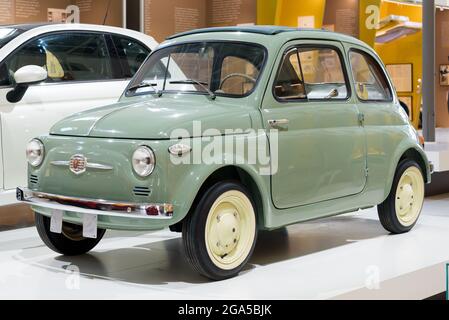 Grünes 1957 Original Fiat 500 Auto auf dem Display in einem Automobil-Showroom, ein ikonisches vintage italienischen Fahrzeug in makellosem Zustand Stockfoto