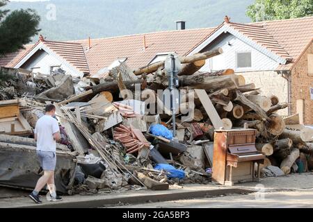 Bad Neuenahr Ahrweiler, Deutschland. Juli 2021. Meterhohe Haufen sperriger Abfälle sind am Straßenrand zu sehen, vor denen ein Klavier steht. Die Reinigungsarbeiten im überfluteten Bereich sind in vollem Gange. Kredit: Bodo Marks/dpa/Bodo Marks/dpa/Alamy Live Nachrichten Stockfoto