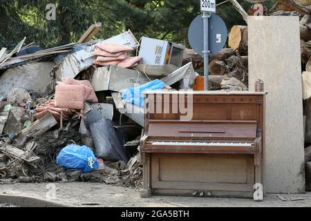 Bad Neuenahr Ahrweiler, Deutschland. Juli 2021. Berge von sperrigen Abfällen häufen sich am Straßenrand meters hoch, davor steht ein Klavier. Die Reinigungsarbeiten im überfluteten Bereich sind in vollem Gange. Kredit: Bodo Marks/dpa/Bodo Marks/dpa/Alamy Live Nachrichten Stockfoto