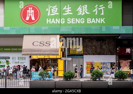 Hongkong, China. Juli 2021. Fußgänger werden gesehen, wie sie die Straße vor der Hang Seng Bank Filiale in Hongkong überqueren.Quelle: SOPA Images Limited/Alamy Live News Stockfoto