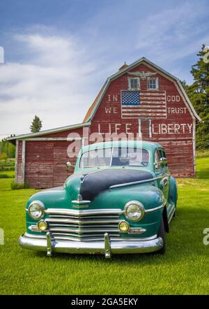 Oldtimer vor der Scheune „in god we Trust“ in Latah, einer Stadt im Spokane County, Washington, USA Stockfoto