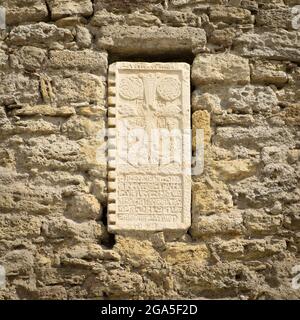 Tontafel mit antiken Symbolen an der Steinwand Stockfoto