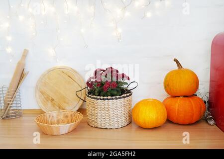 Herbst gemütliches Zuhause Stillleben. Kürbis, Lichter, Blumen auf dem Küchentisch Stockfoto