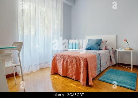 Schlafzimmer mit Steppdecke und Vorhängen Stockfoto