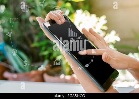 Frau hält das Tablet mit verschwommenen Symbolen für soziale Medien und Technologie in der Hand. Stockfoto