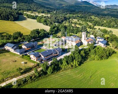 Luftaufnahme der Kirche Santa Eugènia de Nerellà in Bellver de Cerdanya Alp Pirineu Lleida Provinz Katalonien Spanien. Unter den traditionellen Häusern in Stockfoto