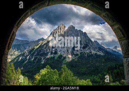 Encantats Gipfel von verlassenen Militärunterkünften im See Sant Maurici, im Nationalpark Aiguestortes i Sant Maurici, Pyrenäen gesehen. Los encantados oder Stockfoto