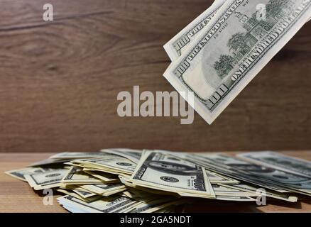 Großer Stapel amerikanischer Dollar auf einem hölzernen Hintergrund. Hundert Dollar Scheine Stockfoto