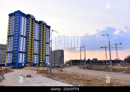 Fassade eines neuen modernen Hochhausgebäudes. Turmkran auf den Bau eines Wohngebäudes. Krane auf Formarbeiten. Makler und echte Es Stockfoto