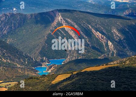 Gleitschirm genießt einen Flug in Ager, Lleida, Katalonien, Spanien. Flug über den Mont-rebei- und Canelles-Stausee. Landschaften von großer Schönheit wie der Natu Stockfoto