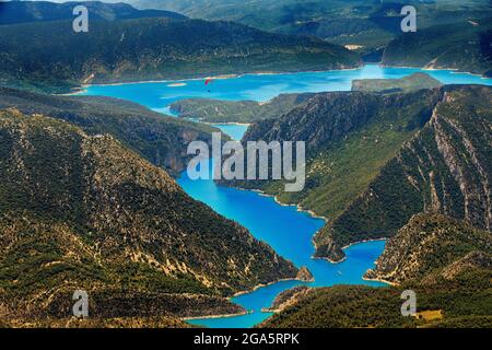 Gleitschirm genießt einen Flug in Ager, Lleida, Katalonien, Spanien. Flug über den Mont-rebei- und Canelles-Stausee. Landschaften von großer Schönheit wie der Natu Stockfoto