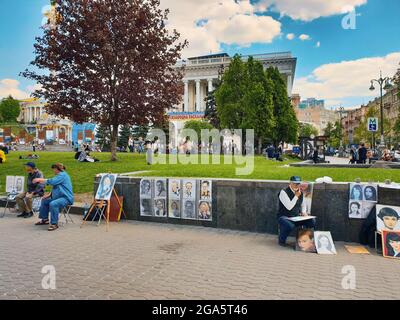 Kiew, Ukraine-28. April 2018: Straßenkünstler zeichnen auf dem Unabhängigkeitsplatz in Kiew, Ukraine, Porträts von Touristen auf Leinwand für Geld. Lokaler Maler Stockfoto