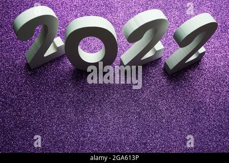 2022 Happy New Year mit Space Copy auf lila Glitzerhintergrund Stockfoto