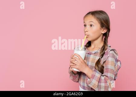 Kind im karierten Hemd trinkender Milchshake isoliert auf rosa Stockfoto