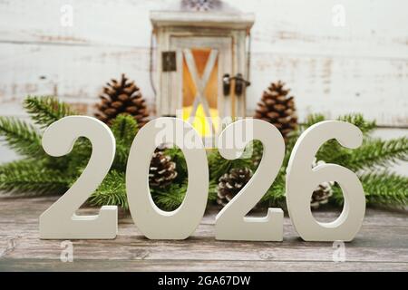 2026 Happy New Year mit weihnachtslaterne dekorativ mit Space Copy auf Holzhintergrund Stockfoto