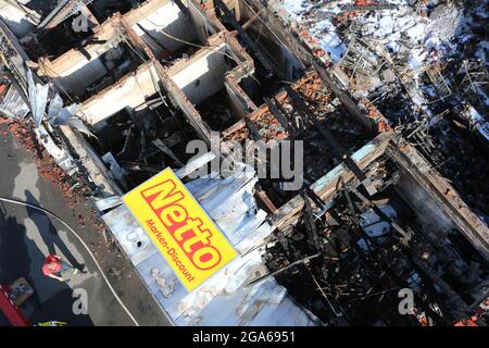 Quedlinburg, Deutschland. Juli 2021. Blick auf den ausgebrannten Supermarkt (Aufnahme von der Plattenspieler-Leiter). In der Nacht waren etwa 77 Notfallmitarbeiter vor Ort, um den Markt kontrolliert verbrennen zu lassen. Die Brandursache und die Schadenhöhe sind noch nicht bekannt. Quelle: Matthias Bein/dpa-Zentralbild/dpa/Alamy Live News Stockfoto