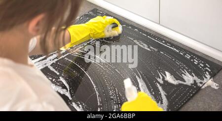 Hausfrau in Gummi Schutzreinigung und polieren Elektroherd Nahaufnahme, Hände und Reinigungsmittel Stockfoto
