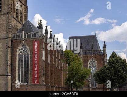 ZUTPHEN, NIEDERLANDE - 25. Jul 2021: Prominentes großes rotes Banner der Weltpresse Foto-Ausstellung hängt von der Walburgiskerk Kathedrale, wo die exh Stockfoto