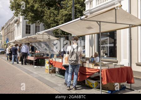 ZUTPHEN, NIEDERLANDE - 25. Jul 2021: Menschen auf einer kleinen Buchmesse im Zentrum der historischen mittelalterlichen Hansestadt während der COVID-19 Pandemie. Stockfoto