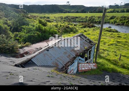 Haus teilweise in einer Sanddüne begraben, Kaupokonui, Taranaki, Nordinsel, Neuseeland Stockfoto