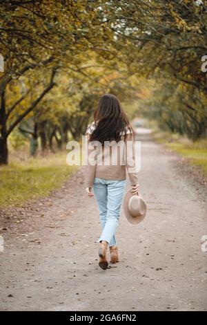 Rückansicht einer Wanderfrau im Herbstpark. Stockfoto