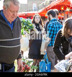 LONDON, ENGLAND - Oktober 12, 2018 Menschen Blumen kaufen an der Columbia Road Blumenmarkt. Diese Londoner principal Blumenmarkt ist jeden Sonntag geöffnet. Stockfoto