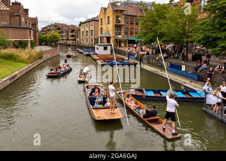 CAMBRIDGE ENGLAND RIVER CAM TOURISMUS UND TOURISTEN UNTER MAGDALENE BRÜCKE AN EINEM SOMMER'S WOCHENENDE EINE FLOTTILLE VON PUNTS UND PASSAGIERE Stockfoto