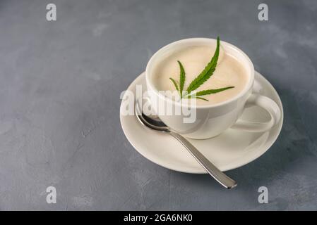 Heißes Kaffeetrink mit Cannabisblatt auf Schaumstoff Stockfoto