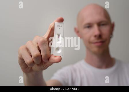 Mann mit negativem Antigen-Covid-Test in der Hand Stockfoto