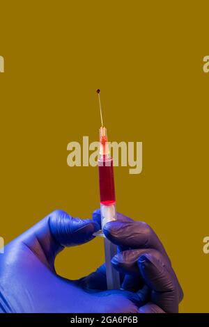 Arzt und Krankenschwester verwenden Schutzhandschuhe, um die Injektionsspritze mit COVID-19 zu füllen Stockfoto