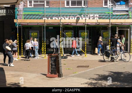 Orford Place Norwich City Centre Paddy Power Buchmacher mit Rudeboy Studios und einem Tattoo- und Piercing-Shop mit Menschen, die draußen für Piercings Schlange stehen. Stockfoto